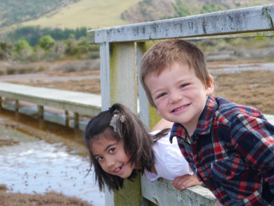 Children looking for crabs in the mud flats from the Aramoana boardwalk. 