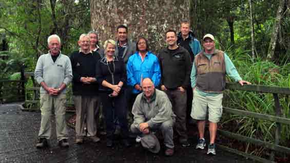 Group photo in front of a large kauri at Puketi Forest. 