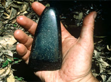 A flat triangular black piece of stone as large as a hand.