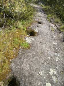 Depressions cut into the rock mark where posts stood. Photo: Melanie Charters.