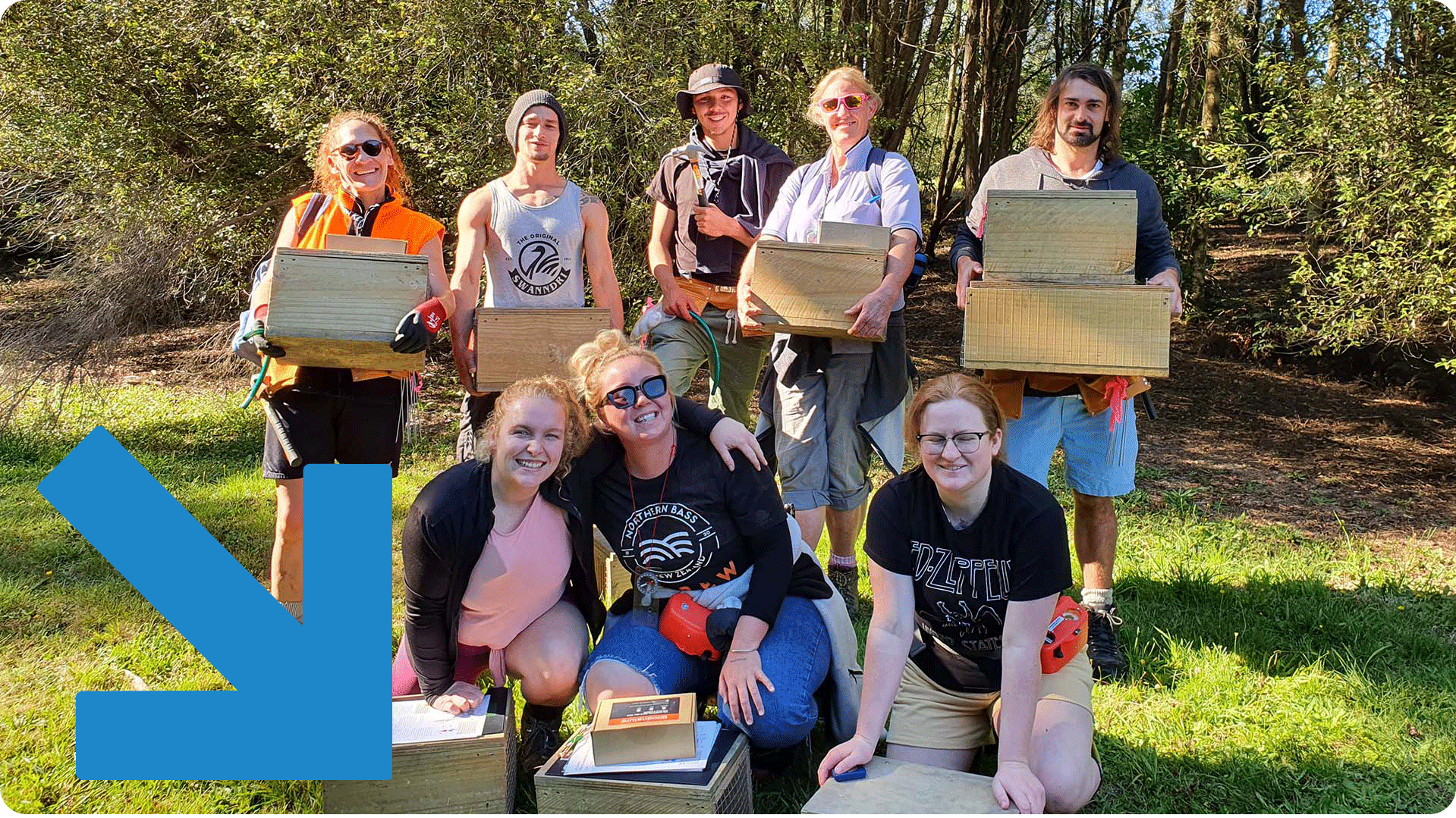 Trap training group stands in the sun smiling and holding traps.