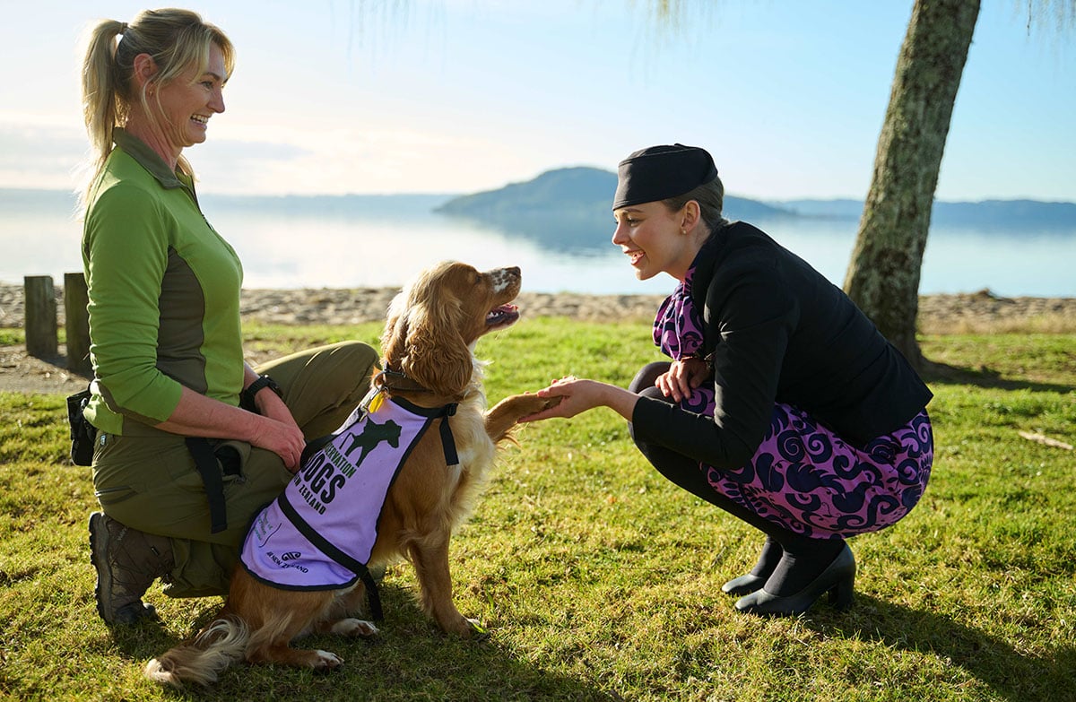 DOC Conservation dog handler Adeline with her dog, Blaze and Meghan, Air NZ flight attendant.