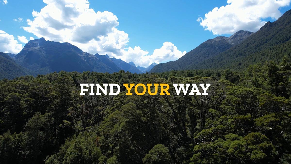 Wooded hills with mountains in the background, 'Find your way' message splashed across.