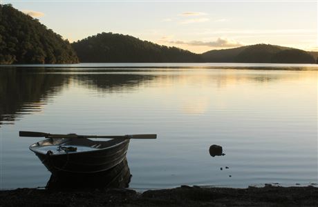 Boat by lake at sunset.