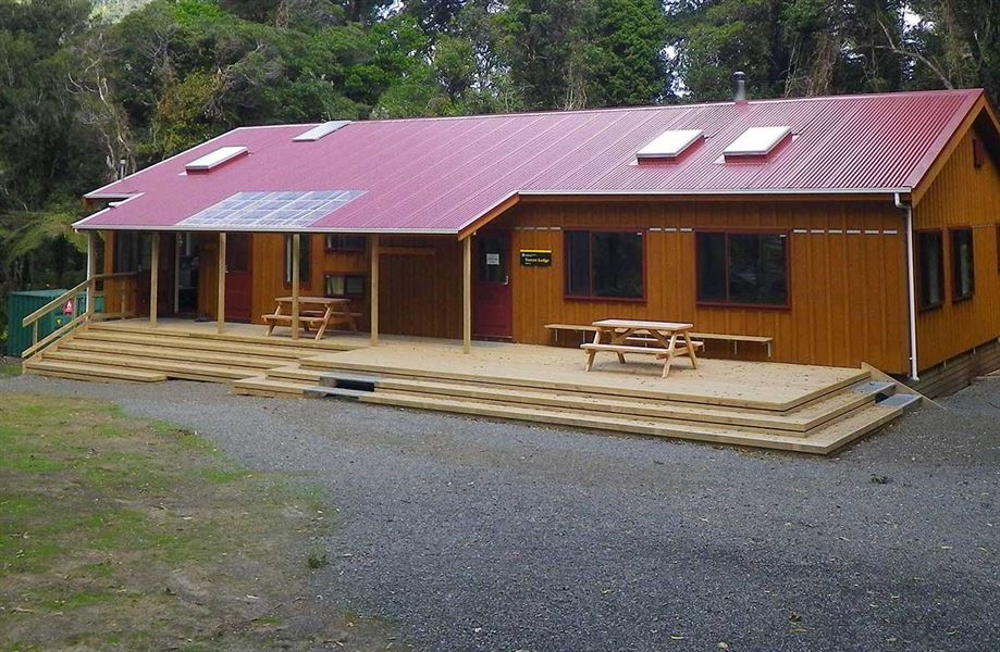 Tūrere lodge, a reddy brown rectangular building with a red corrugated roof. 