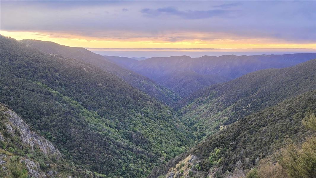 Distance sunrise behind greenspace and hills. 