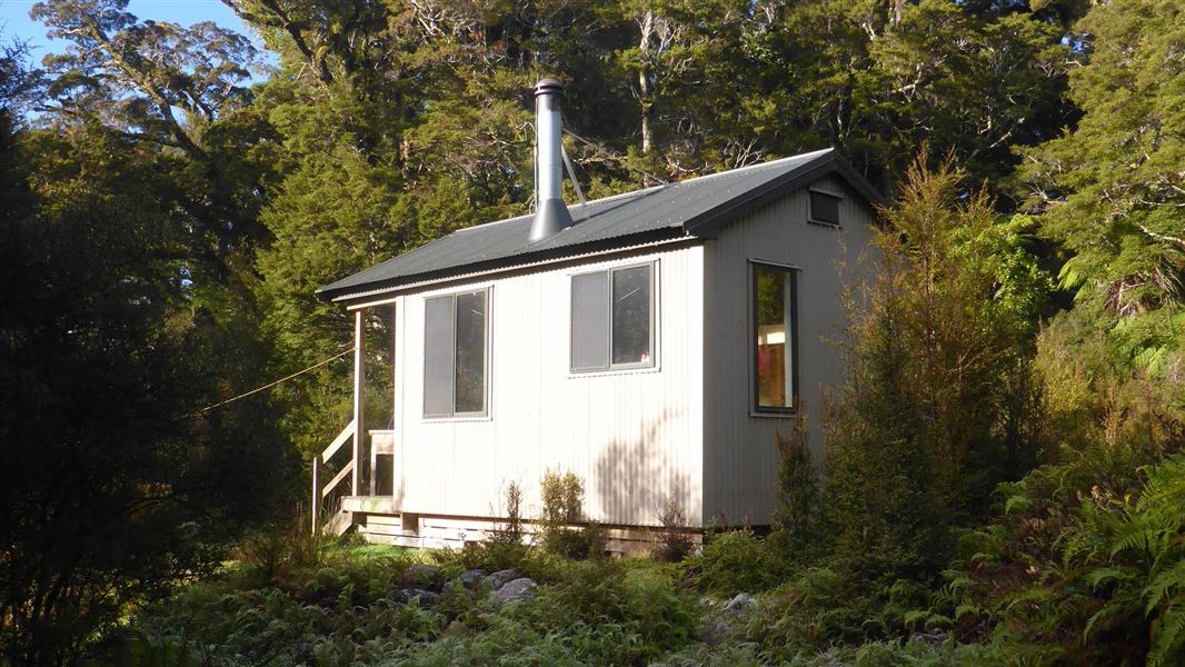 A small corrugated hut nestled in the bush. 