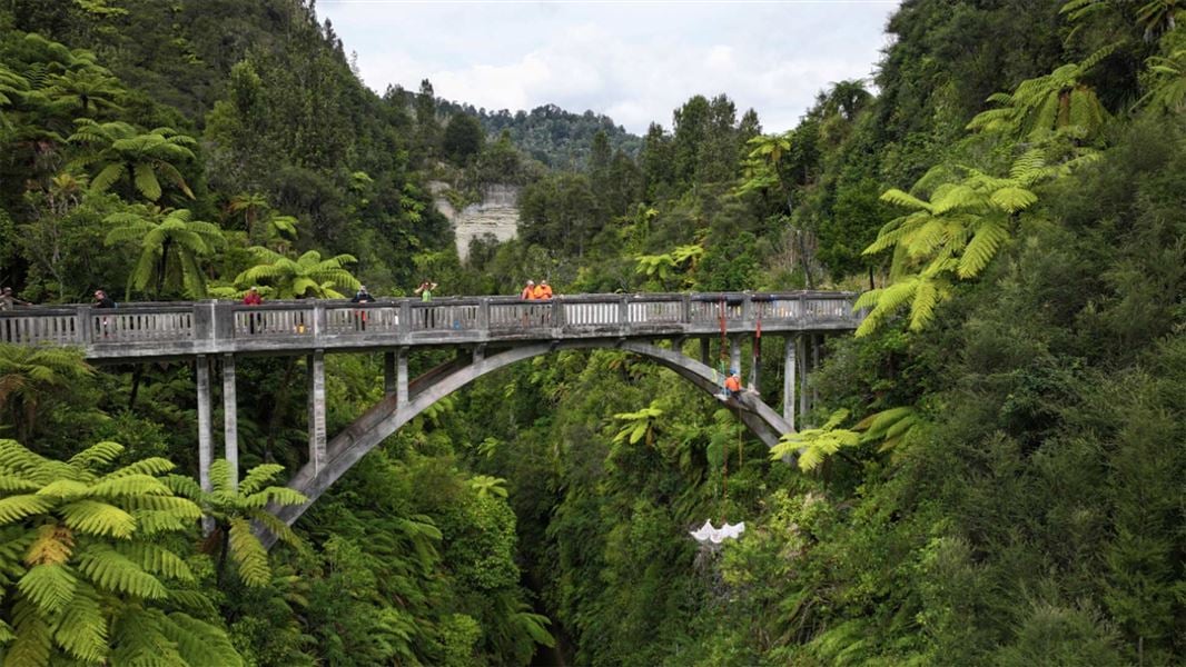 An abseiler conducts maintenance work on the Bridge to Nowhere. 
