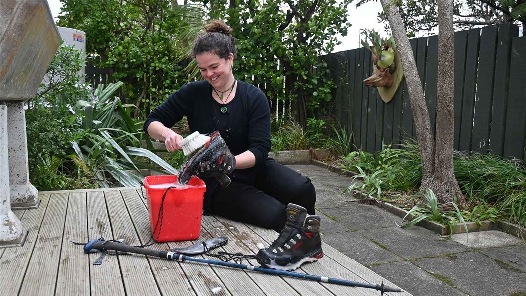 Woman cleaning boots and poles. 