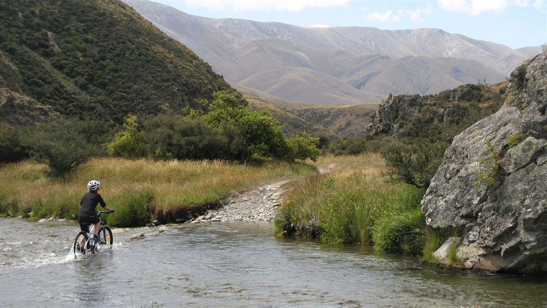 Cyclist riding across a river.
