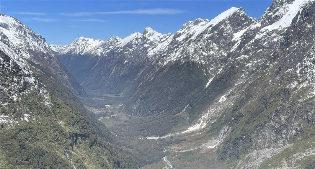View up MacKinnon Pass from a helicopter with avalanche damage in the background.