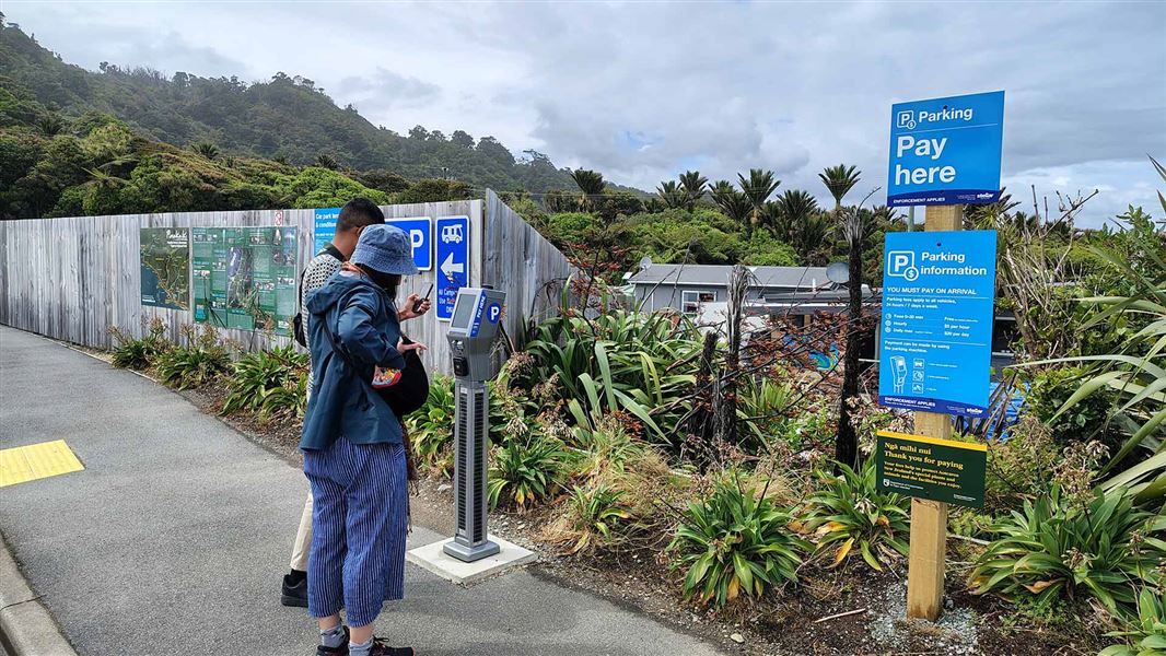 Couple looking at parking signs. 