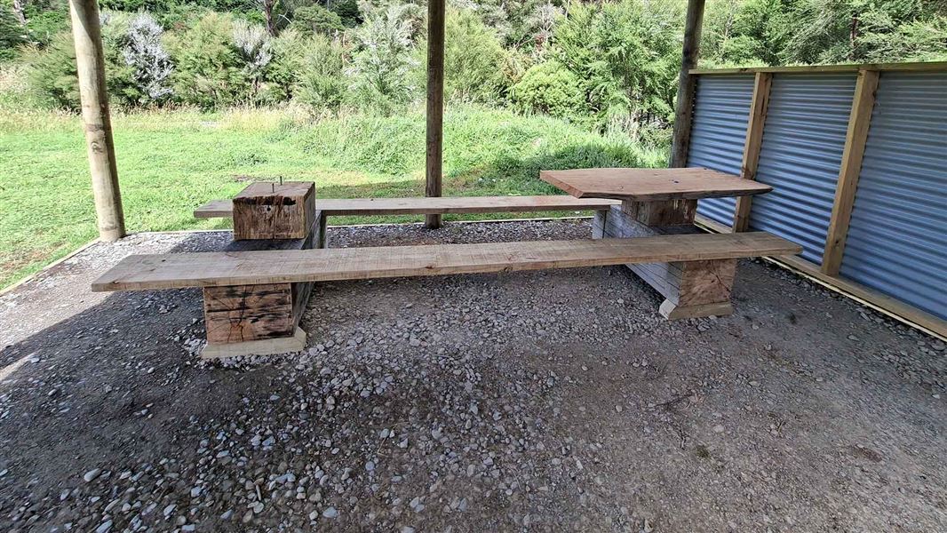 Large picnic table with its top hacked off except for on small section. 