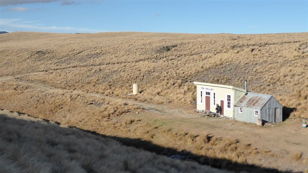 Hut in a tussock covered high country landscape.