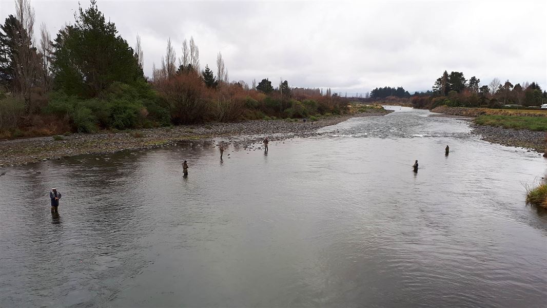 An example of multiple fishermen enjoying a river by following fishing etiquette.