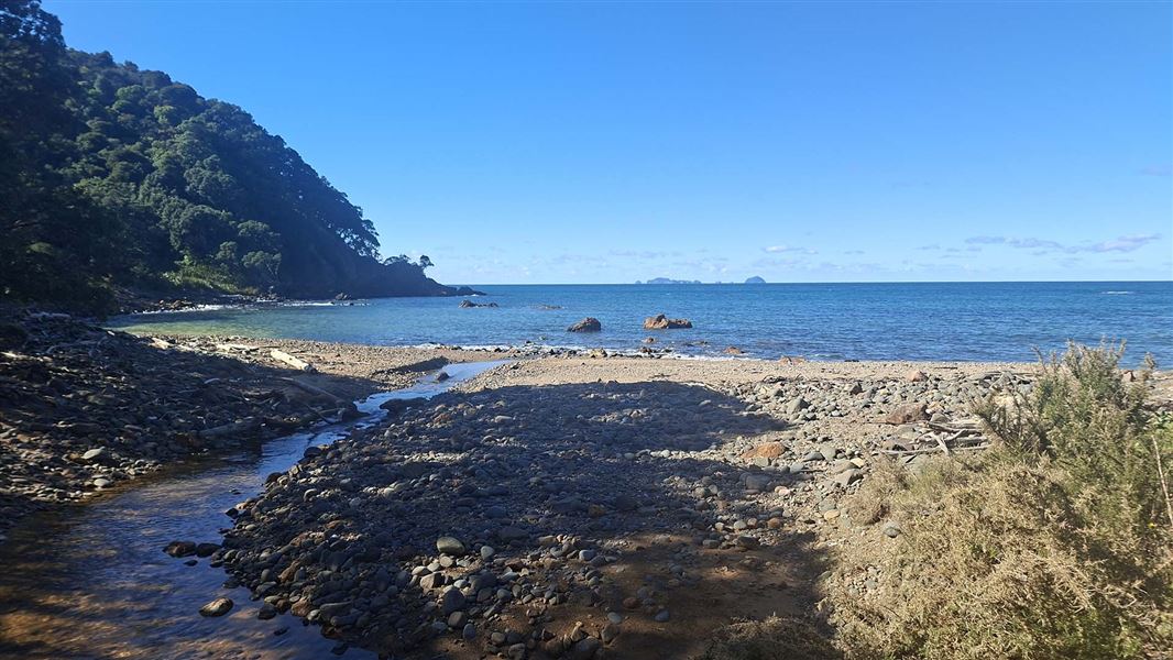 View across a small, stony beach out to sea.