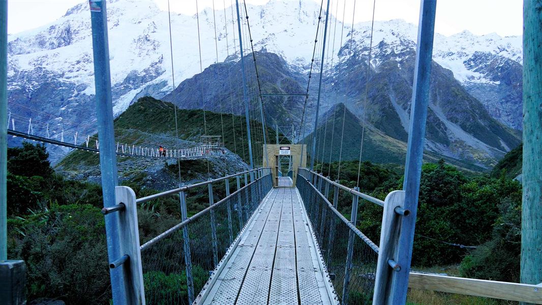 View coming on to a suspension bridge on a blue sky day. 